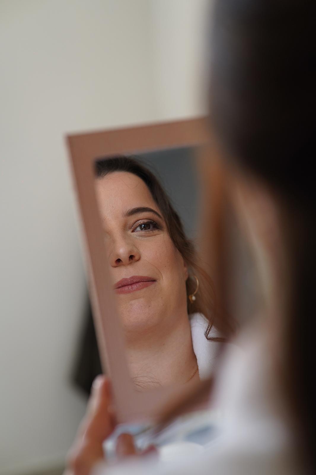 La mariée découvre son maquillage naturel dans le miroir