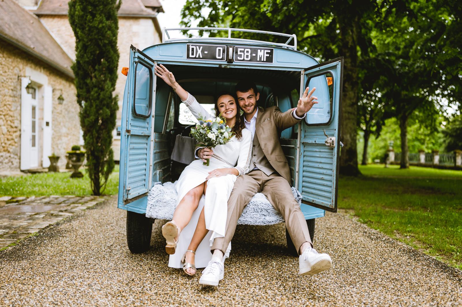Mariés dans une 2CV vintage après la cérémonie en Dordogne
