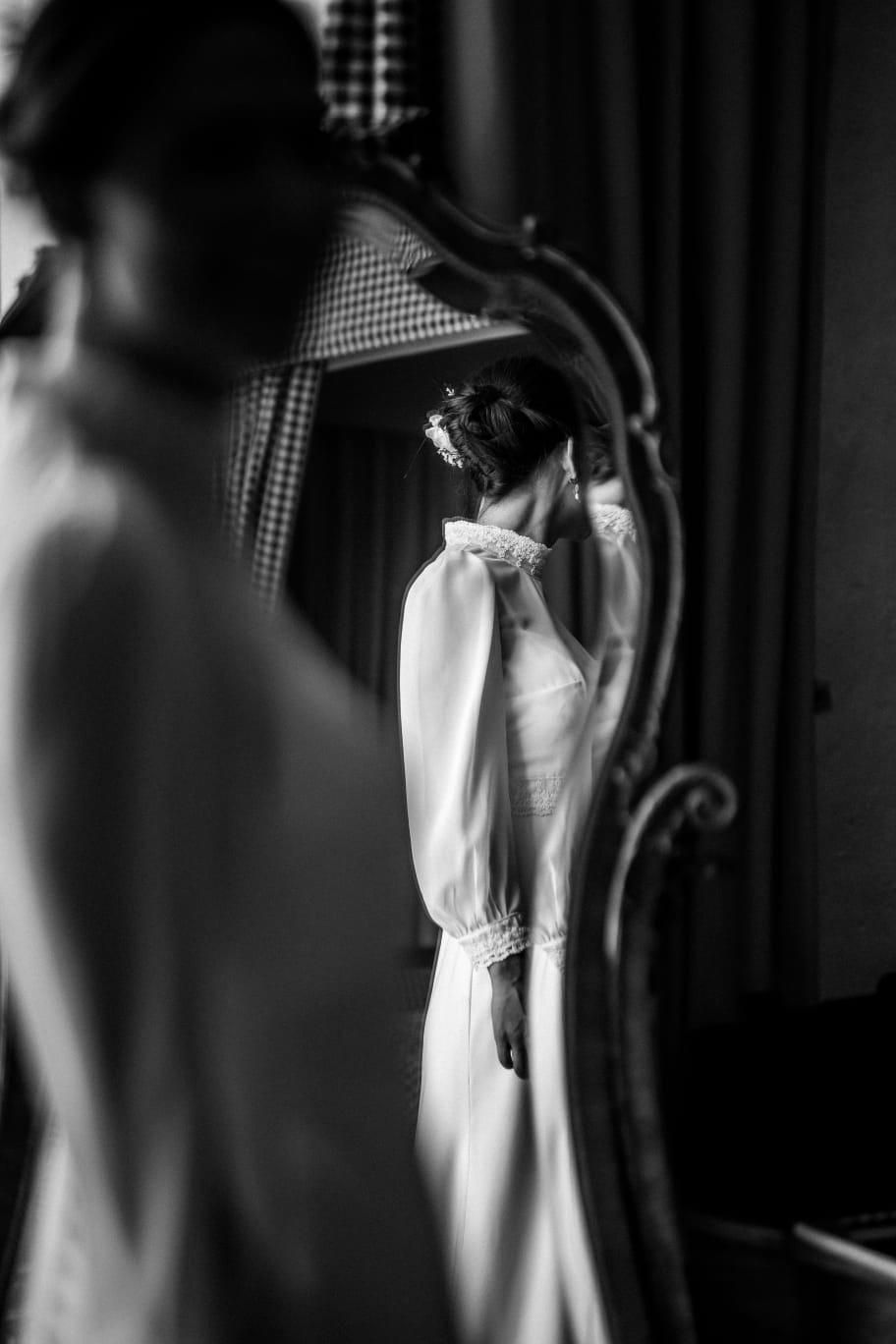 Portrait noir et blanc d'une mariée coiffée devant un miroir